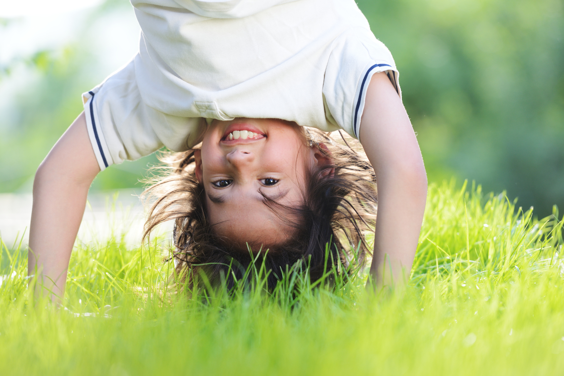 kid doing a handstand in the grass
