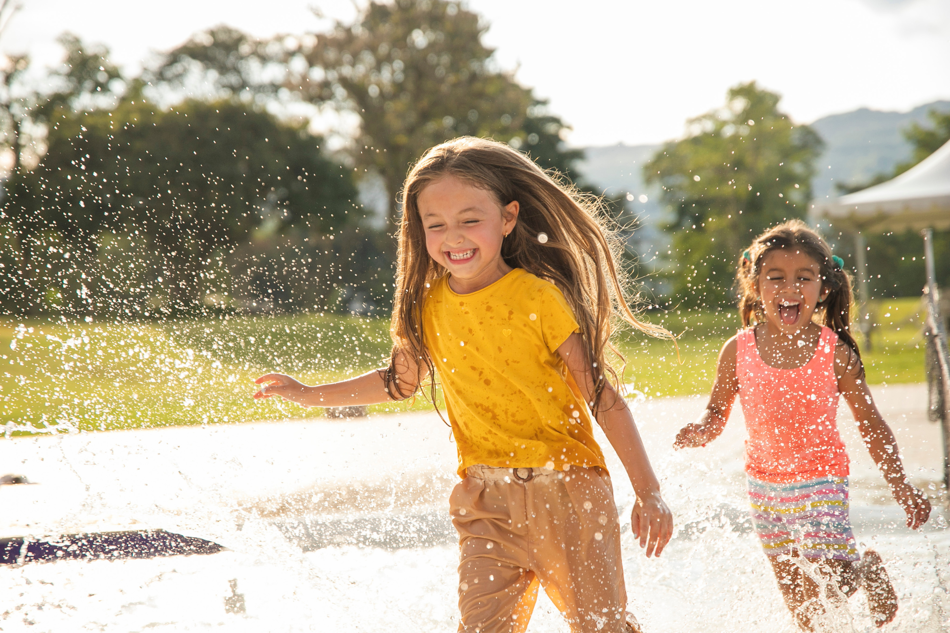 children playing in sprinklers