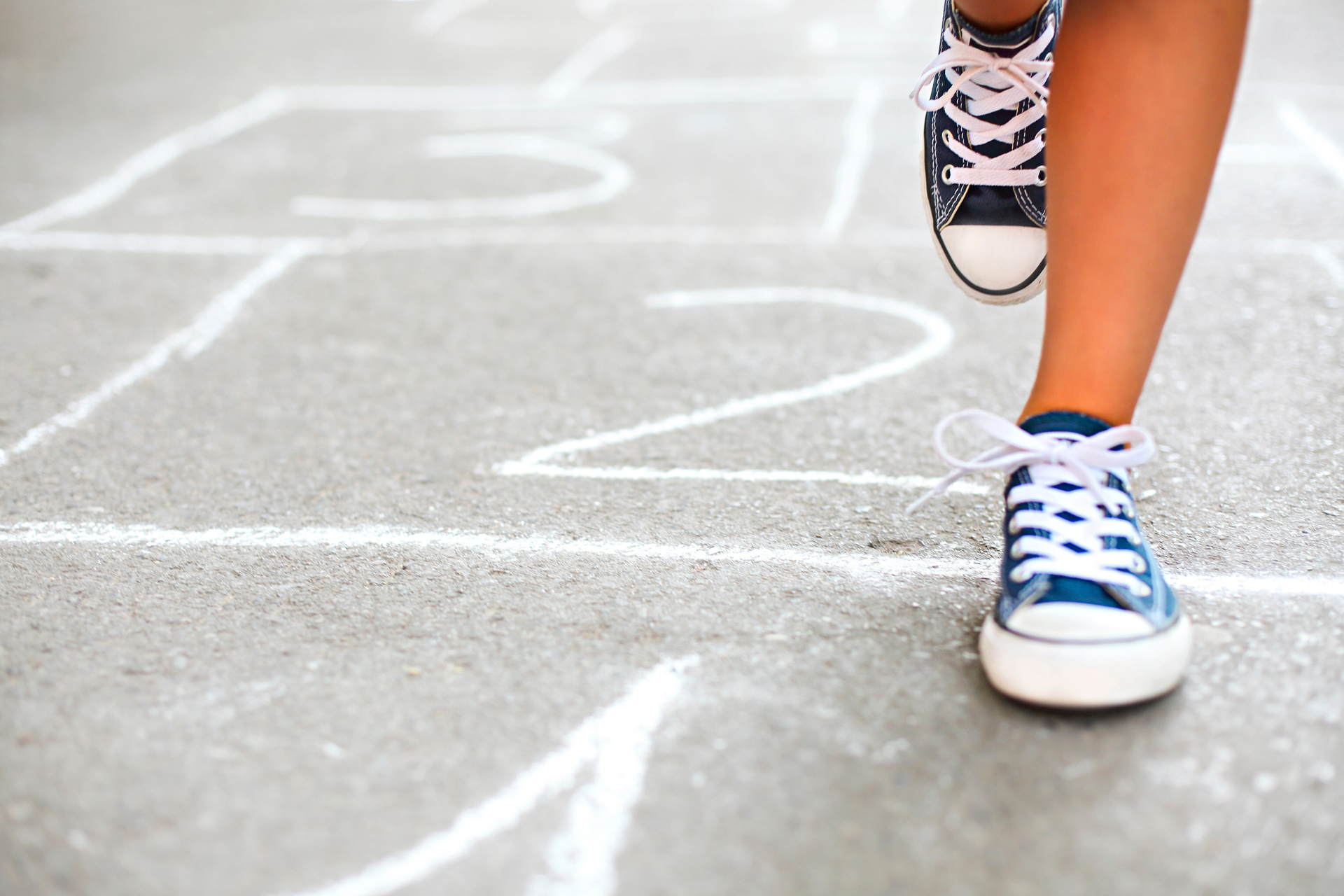 child playing hopscotch on playground